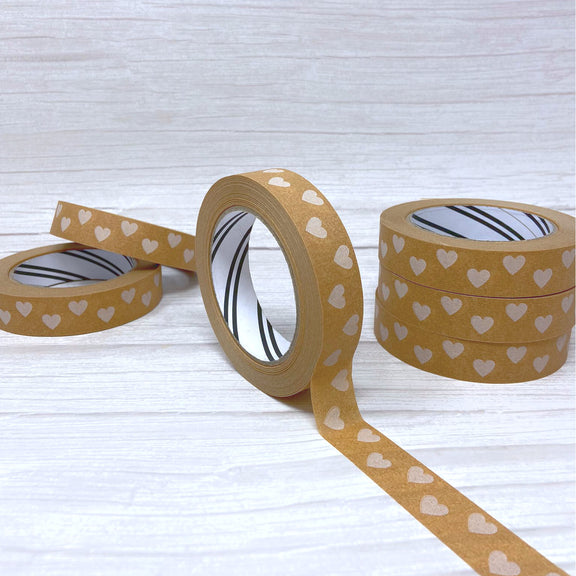 rolls of brown paper tape with white heart design stacked up on table